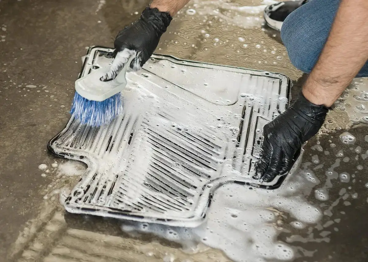 A set of clean and dry rubber car floor mats stored in a garage.